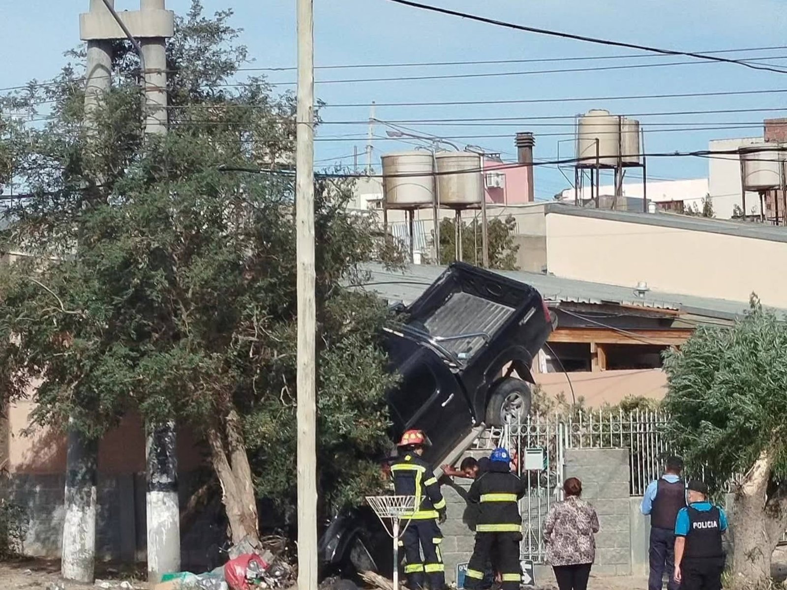 una Toyota Hilux descontrolada terminó arriba de la reja de una casa y debió ser removida con una grúa