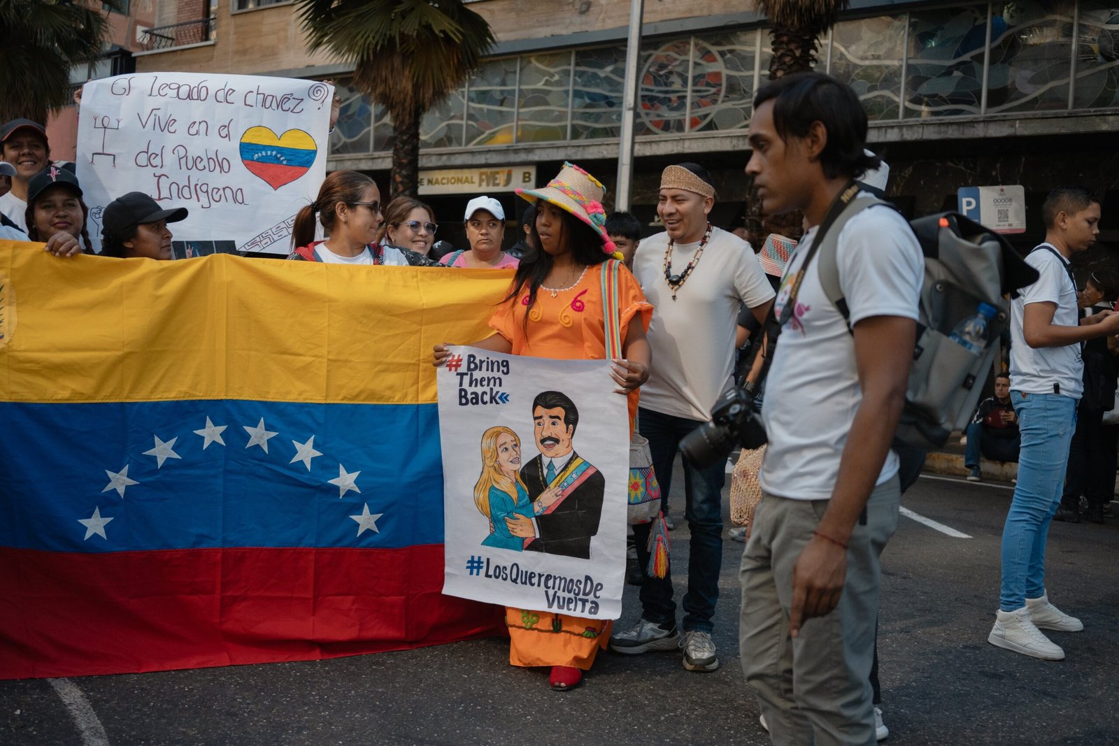 A woman holds a sign with images of Nicolás Maduro and former First Lady Cilia Flores, during the peace march in Caracas on April 9, 2026. 