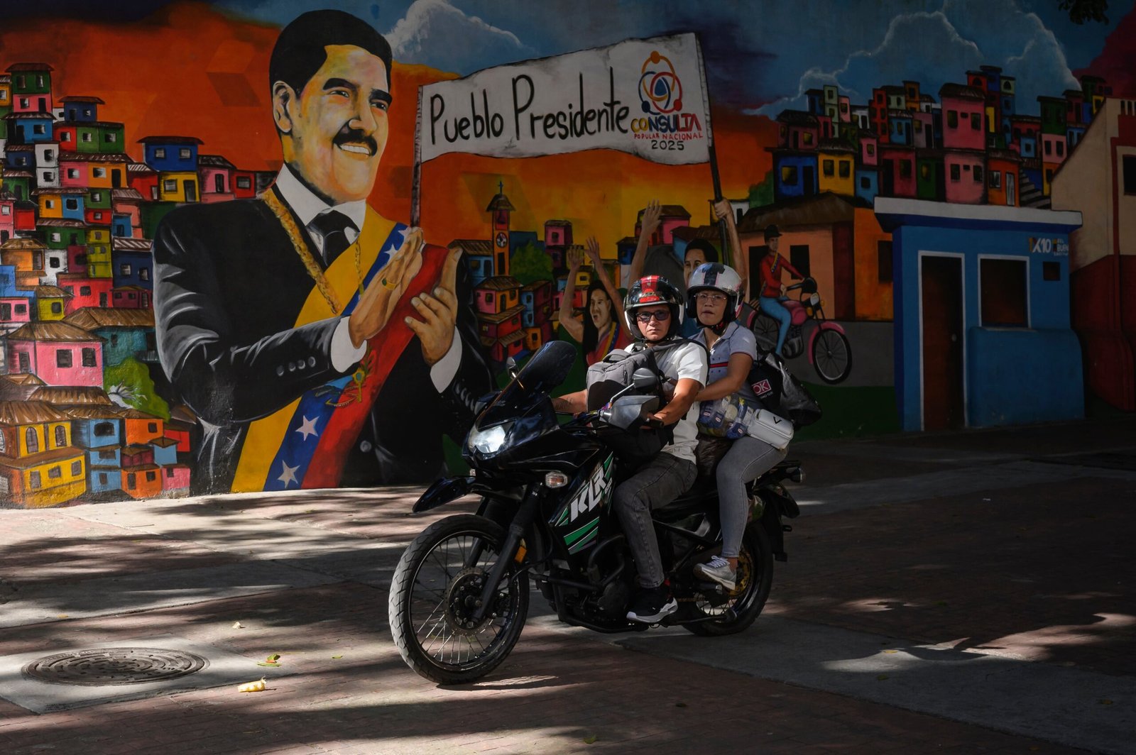Personas pasan frente a un mural de Nicolás Maduro, en Caracas, Venezuela el 22 de Noviembre de 2025.