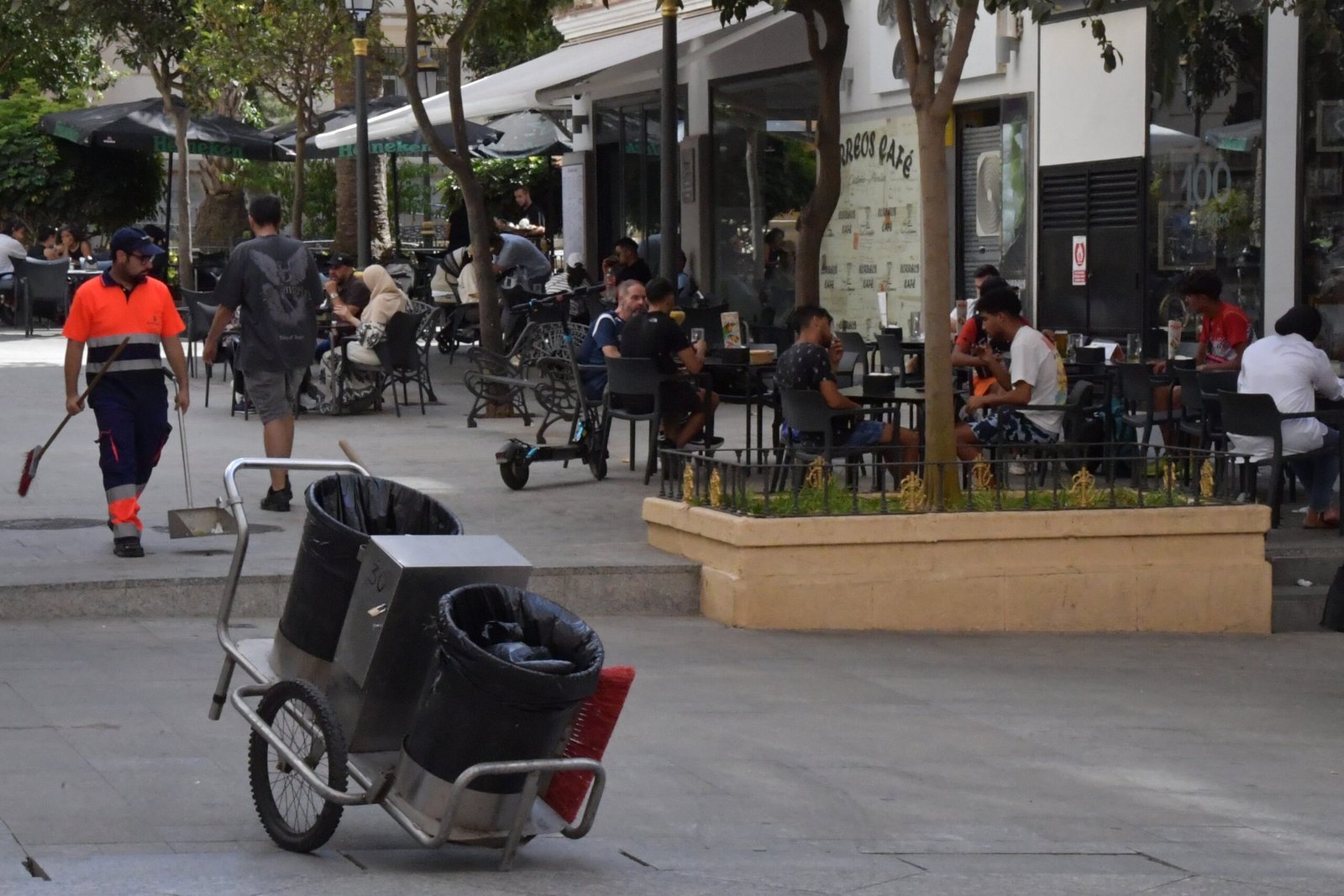Un barrendero y clientes en terrazas, el jueves en Ceuta.