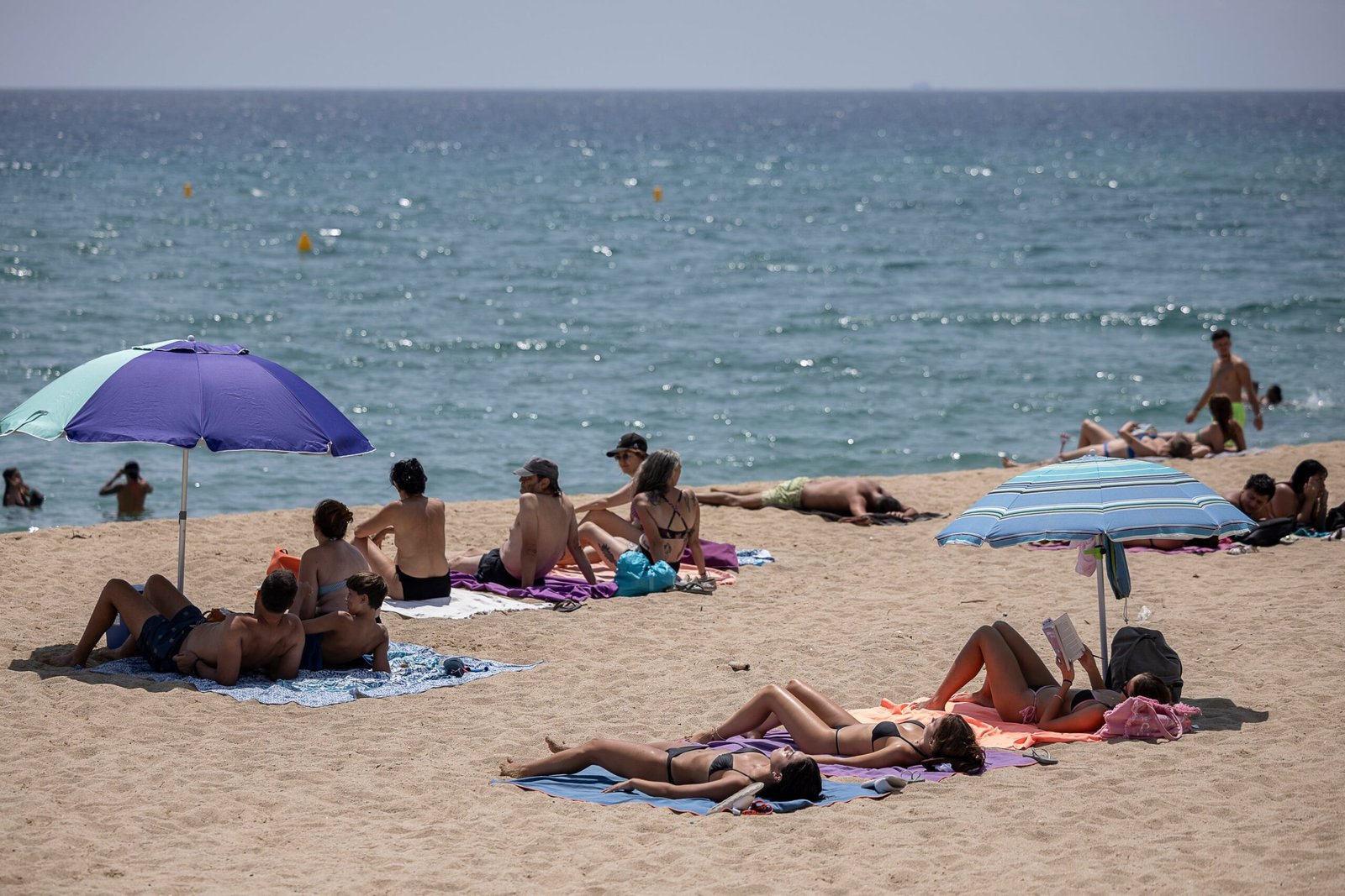 Varias personas tomaban a finales de julio el sol en la playa de les Barques, en Montgat (Barcelona).