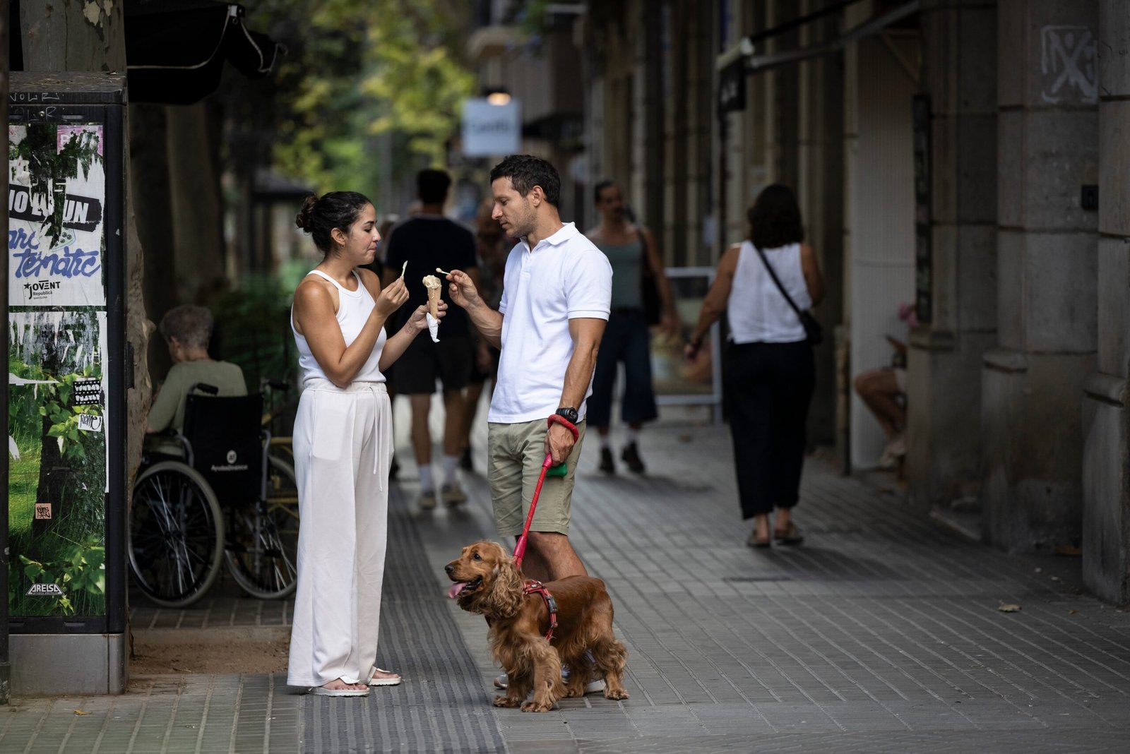 Una pareja comía un helado en la calle Consell de Cent de Barcelona, el martes.