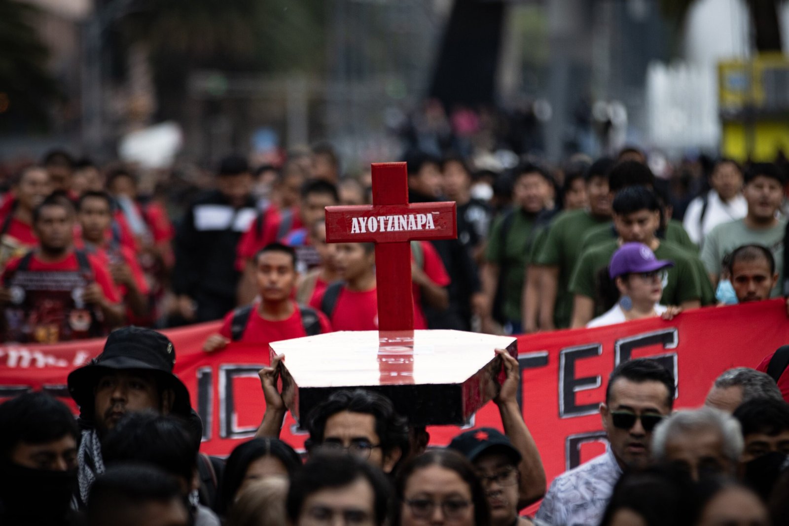 Estudiantes normalistas cargan cruces durante la marcha.