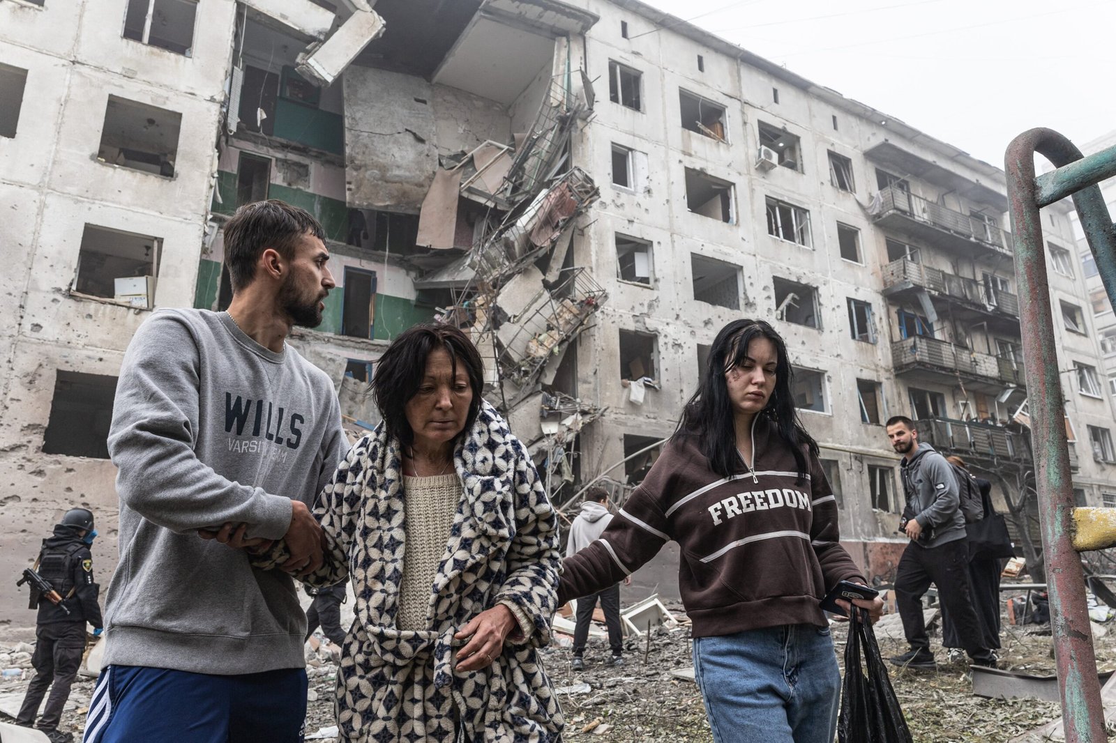Dos vecinos ayudan a una mujer herida tras un ataque aéreo ruso contra un edificio residencial en Sloviansk (Ucrania), este domingo.